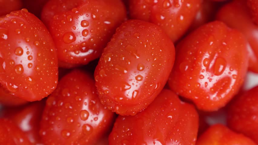 Vivid Depiction Of Rotating Cherry Tomatoes With Water Droplets Indicating Freshness And Purity