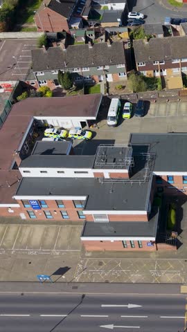 Cheshunt police station vertical orbit showing the station buildings, car park and nearby almshouses along the main road in Hertfordshire, England on a clear day.
