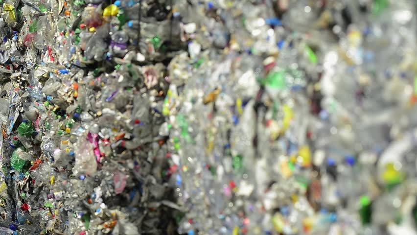 Huge bale of pressed plastic bottles and other pet packaging ready for recycling. Environmental concept of waste management and processing