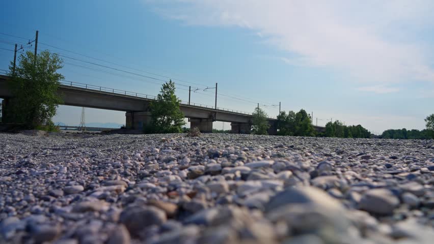 Passing train on the bridge above dry rocky river creek