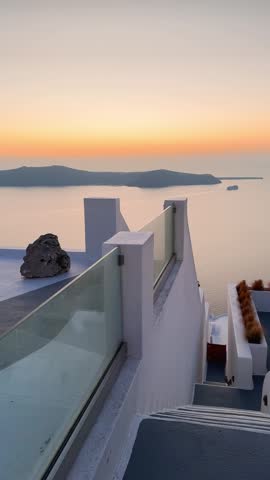 
Beautiful sunset in Santorini island, Greece. White architecture with sea view. Blue sea and the blue sky at sunset. Summer travel and vacation. Vertical video

