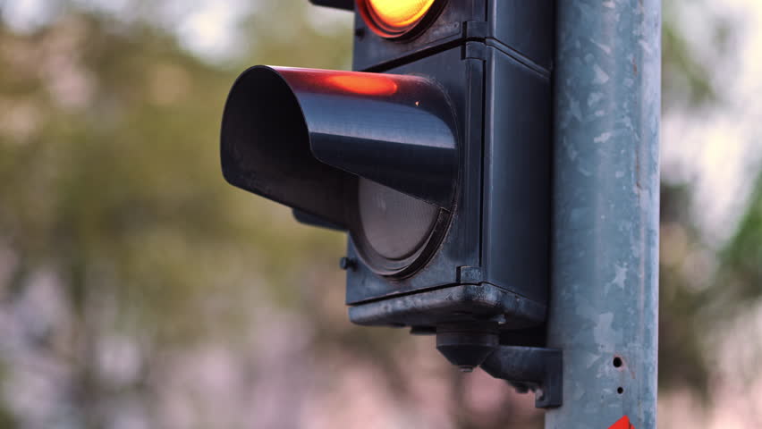 Green traffic light signal illuminated at urban intersection close-up showing go permission, 4K selective focus