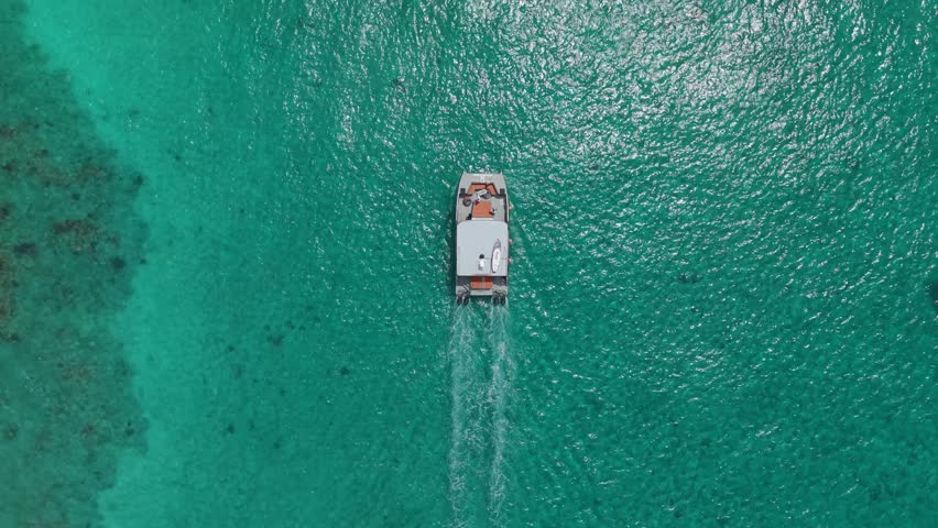 Catalina Island in La Romana Dominican Republic with boats over clear turquoise Caribbean water. Tropical travel and tourism paradise scene. Aerial top down flyover.