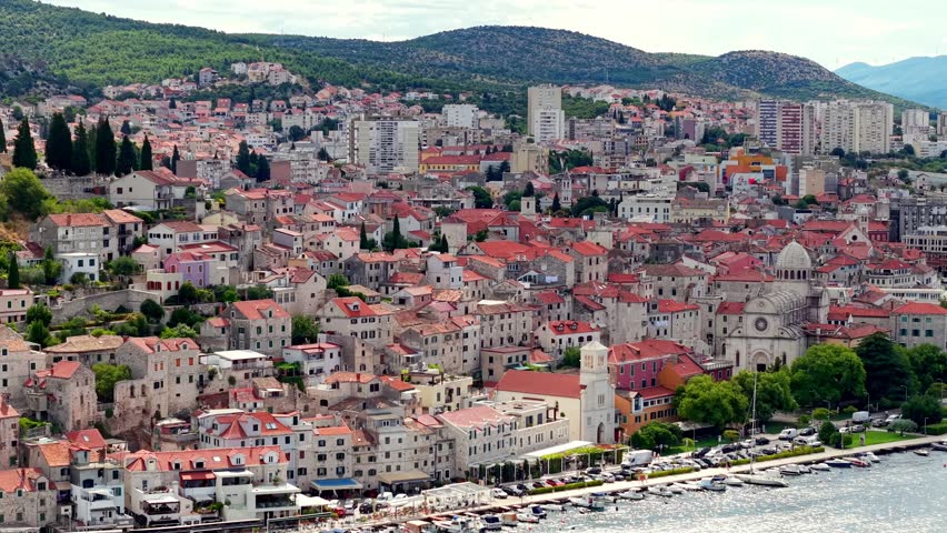 Panoramic view of Sibenik city in Croatia featuring the St. James Cathedral and traditional red-roofed houses along the Adriatic coast