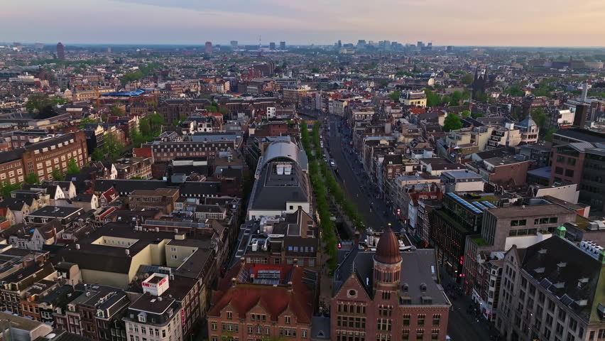 Aerial view of Amsterdam city at sunset, Netherlands. Amsterdam Central Station. Canals with boats in the center city, old centre 