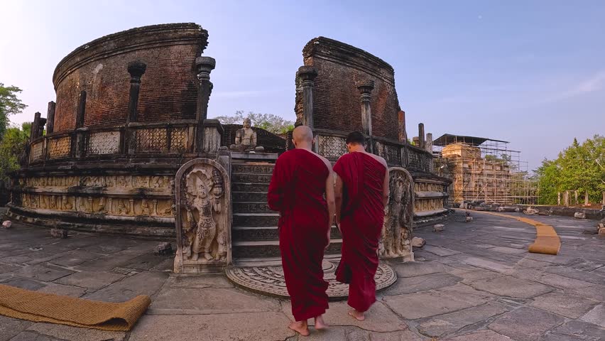 Buddhist monks walking through ancient ruins of Polonnaruwa Sri Lanka traditional religious culture at historical unesco world heritage site