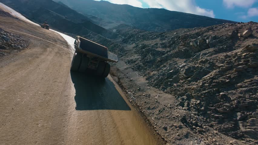 Aerial fpv view of open pit quarry with haul truck and excavation machinery for mining background and industrial work.