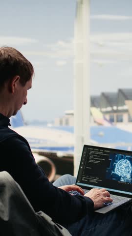 Vertical Video IT engineer, working with AI coding, testing machine learning systems, laptop in airport lounge, before boarding. Travel environment with deep learning innovation and work anywhere job.