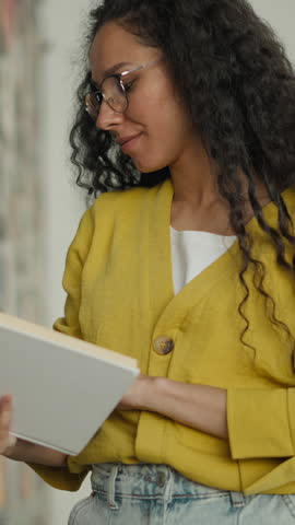 Happy Arabian Hispanic woman student smiling looking at camera library university bookstore reader reading favorite book study smile hobby female girl learning literature bookworm education college