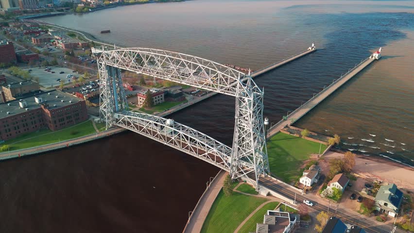Aerial view shows Duluth Aerial Lift Bridge over harbor on sunny day in Minnesota