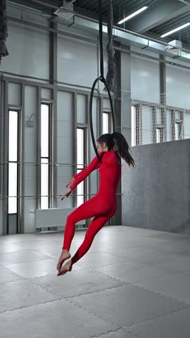 A graceful gymnast trains on an aerial hoop.