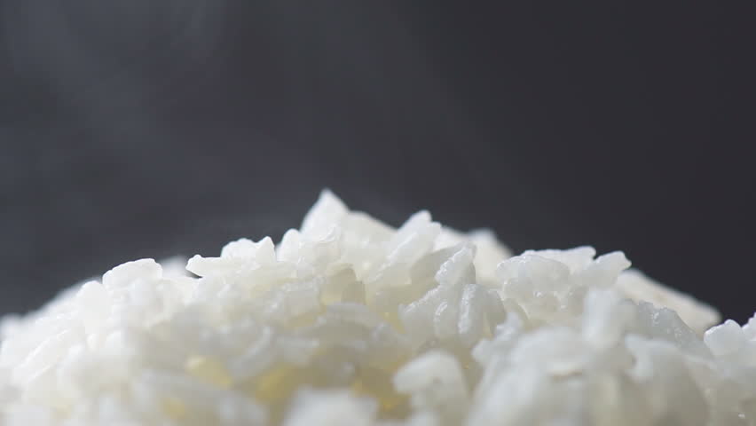 Freshly brewed hot fragrant rice. Macro shot. Bowl of Jasmine rice. Closeup view of long-grain variety of aromatic rice. Healthy eco food. Product of organic farming.
