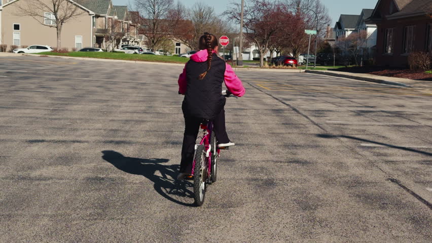 Child riding a bicycle in a quiet suburban neighborhood. daytime kids activity, independence, and healthy lifestyle in residential area.