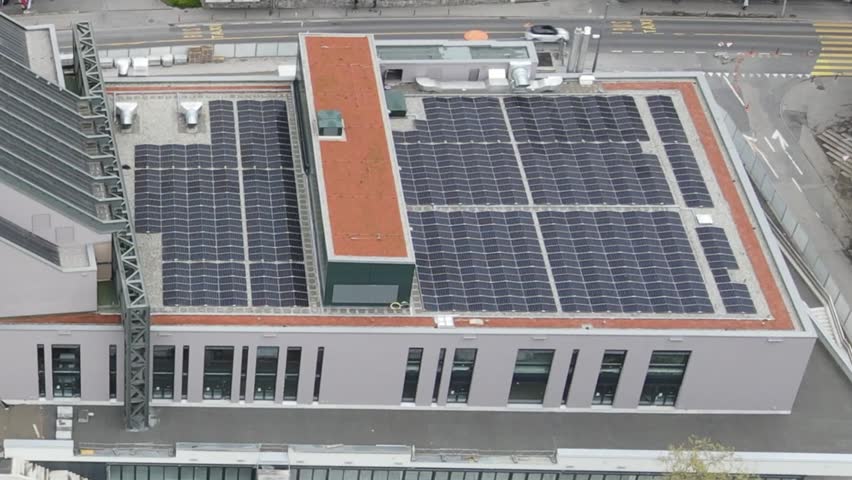 Aerial view of solar panels installed on a modern building rooftop, showcasing renewable energy production, sustainability, and green urban infrastructure.