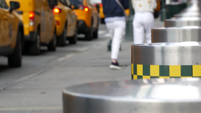 Manhattan Midtown street New York City, United States. Defocused row of yellow taxi cars. Many taxi cabs in line on 8th avenue near Penn Station. Taxi queue, urban road traffic, passenger transport.