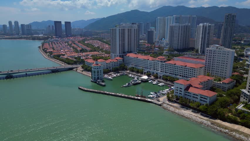 the tranquil marina, urban development, and modern condominiums along the picturesque coast of Penang, Malaysia. Brilliant aerial view