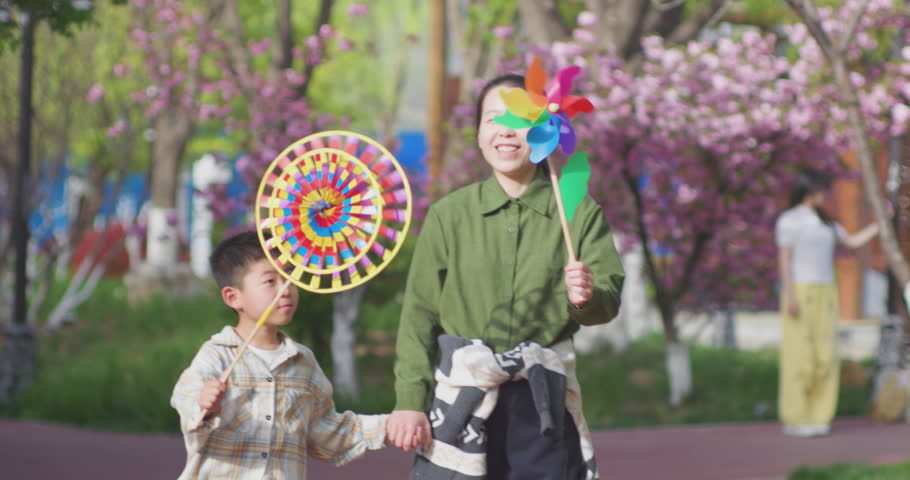 A Chinese mother and child play outdoors wearing willow leaf-woven clothes.