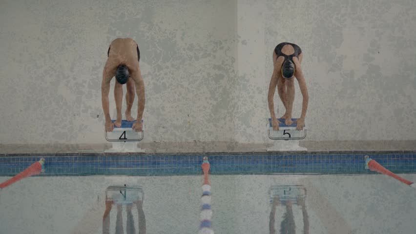 Starting horn sounding, two swimmers simultaneously pushing off, diving into water to begin heat. Athletes, pool, lanes, blocks, splash, plunge, motion