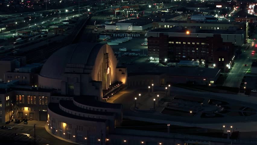 Aerial view of Cincinnati Union Terminal, a Beaux-Arts style train station, illuminated at night, contrasting with the dark urban landscape, Cincinnati, Ohio, United States.