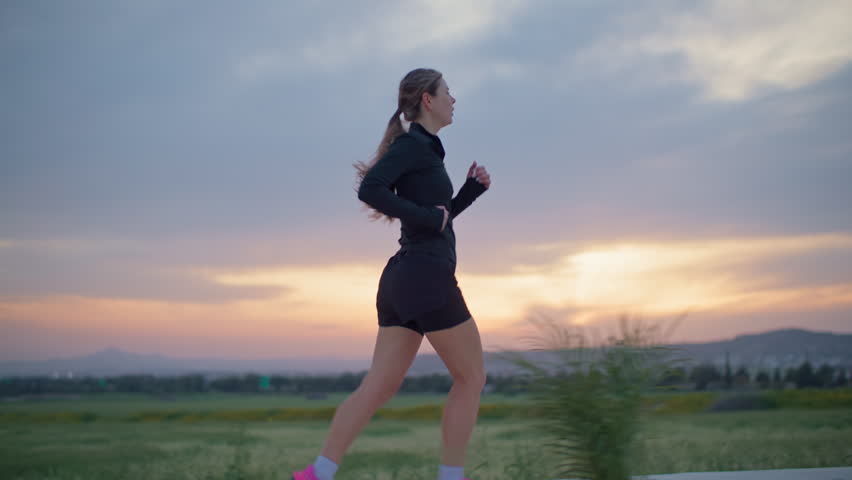 Woman jogging at sunset in mountain landscape, evening workout and active lifestyle running in beautiful nature