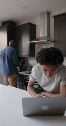Father Supporting Child Education in Kitchen with Laptop computer Technology