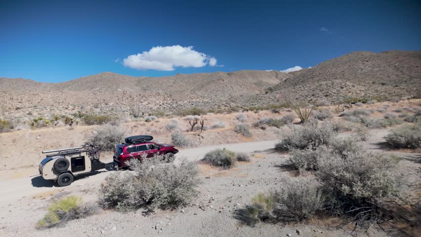 Aerial views show a teardrop camper and SUV navigating trails in Anza Borrego Desert State Park near Prune Canyon in California.