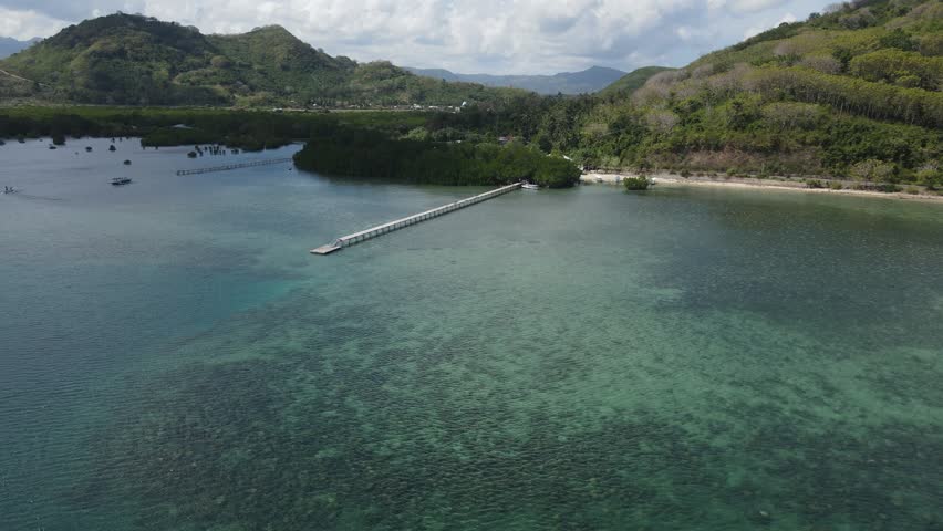Aerial perspective of coastal landscape with tropical vegetation and ocean in Sekotong.