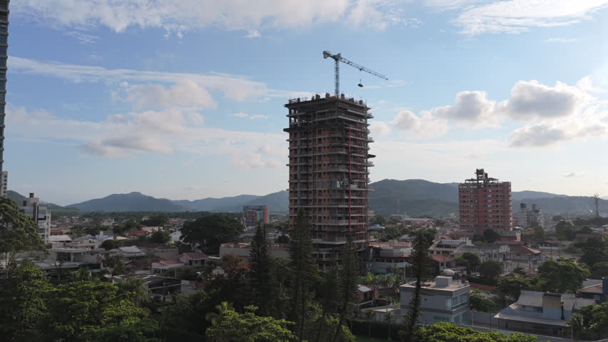Aerial drone view of high-rise building under construction with crane in Penha, Santa Catarina, Brazil.
