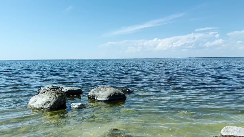 Sunny sky clouds over sea water background. Tourist Travel destination  with sea Horizon.  summer season in 4K. People enjoying good weather.