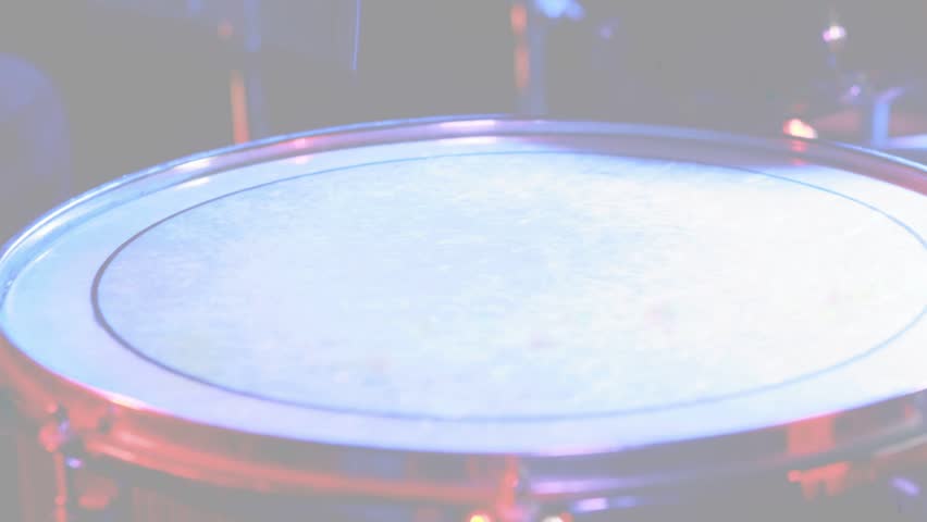 Camera revealing drum head while tom and cymbal reflecting blue magenta lights for music. Percussion, macro, stage, studio, stock, metallic, reflections