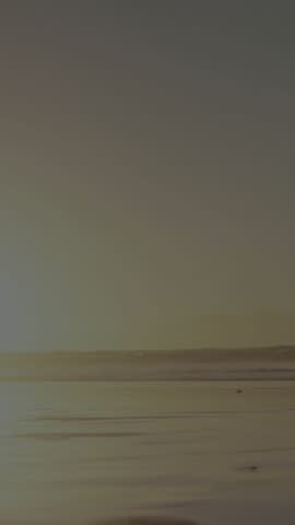 Woman entering and running on shore, throwing scarf with animated orbs layering shadow for health. Silhouette, backlit, sunset, beach, horizon, motion, vertical video