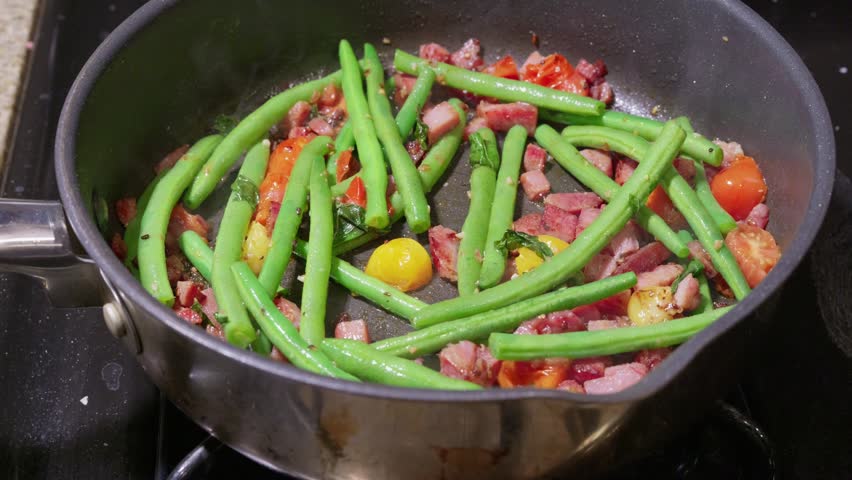 Green beans and cherry tomatoes sauté with diced bacon