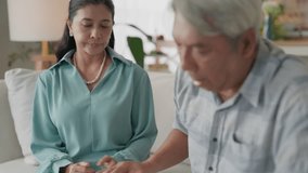 Senior couple holding hands on sofa at home in living room, comfort support care empathy in relationship, caregiving spouse offers gentle hand holding, family bond and emotional reassurance - Powered by Shutterstock - Get 15% off with code: PIKWIZARD15