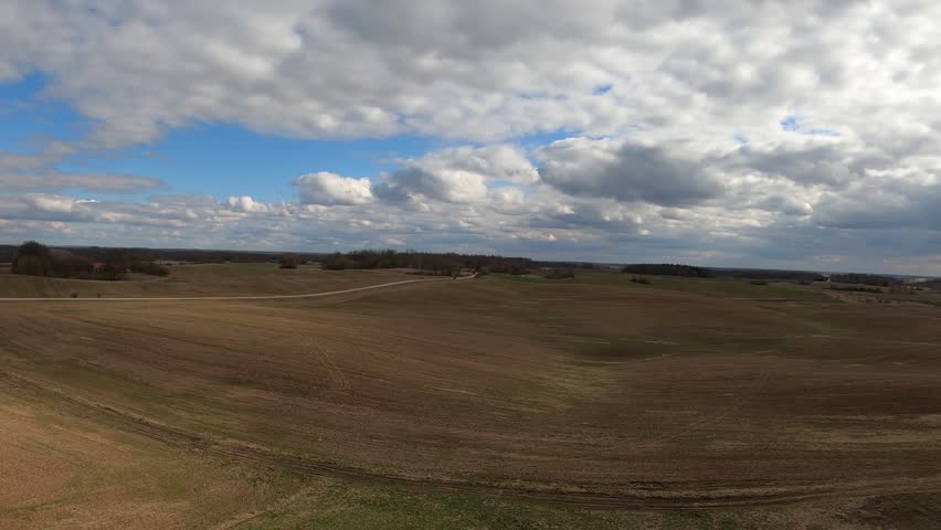 Rolling hills countryside landscape viewed from an elevated position under a dramatic cloudy sky.
