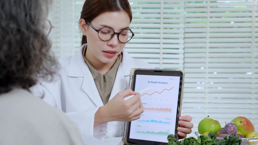 Asian nutritionist showing AI health analysis graph on tablet to senior patient, doctor using technology for medical data tracking, medical diagnosis for diet control, consulting and nutrition.