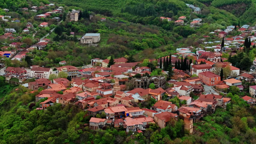 Aerial drone view of Sighnaghi, Georgia, showcasing the hilltop town, surrounding landscape, and charming architecture from above in clear daylight.
