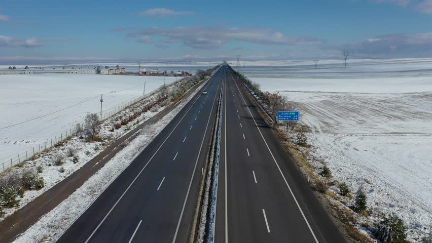 Aerial View of Highway in Winter Landscape with Snow Covered Fields.