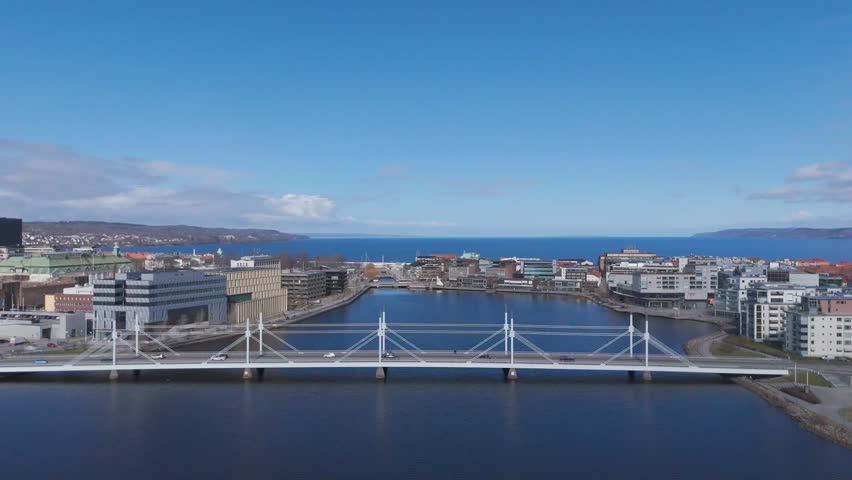 Aerial view of modern cable stayed bridge crossing coastal waterfront in Incheon South Korea, urban cityscape with buildings and calm water under clear blue sky