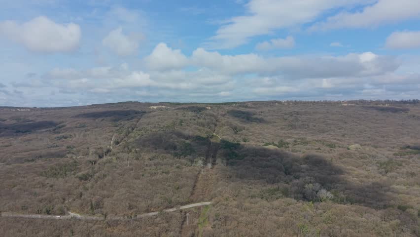 Aerial view of open hills under cloudy sky with natural landscape and wide horizon