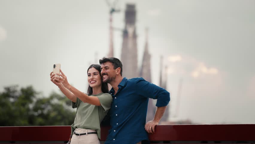 Video of beautiful couple taking photos of themselves with smartphone in the city