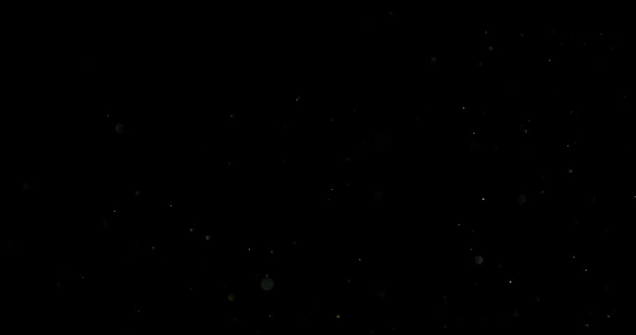 Super slow motion (1000 fps) floating dust particles in the air, isolated on black background. Cinematic atmospheric shot with soft light, depth and abstract texture.