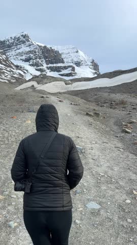 Woman walking towards Athabasca Glacier at Columbia Icefield in Jasper national park, Canada