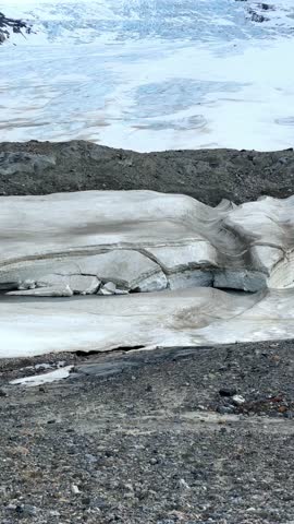 Athabasca Glacier flowing inside Columbia Icefield valley in Jasper national park, Canada