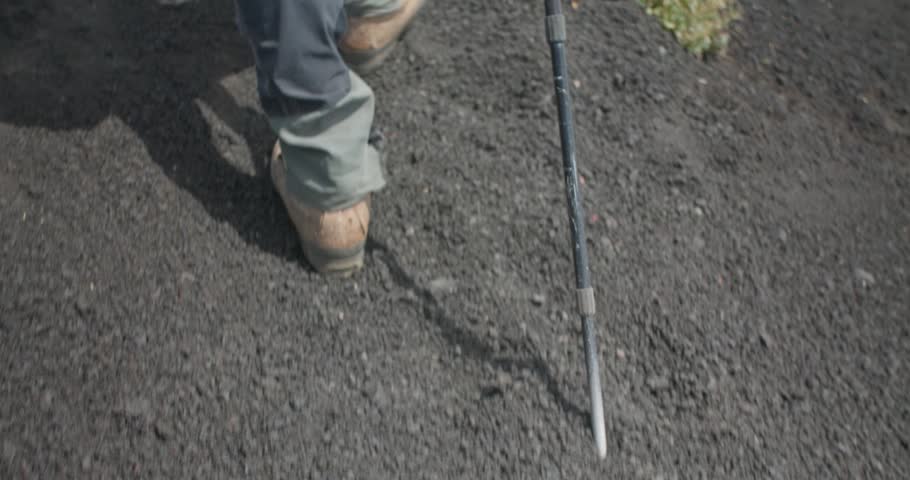 Slow motion of a hiker walking on dark volcanic terrain, Etna Volcano, 4k
