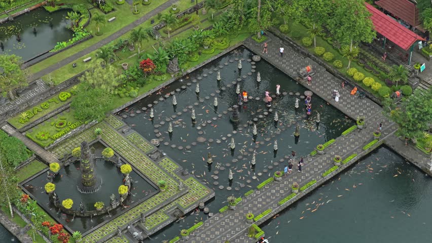 Aerial view of tourists walking around the beautiful tirta ganga water palace, a former royal palace with pools, fountains, and gardens