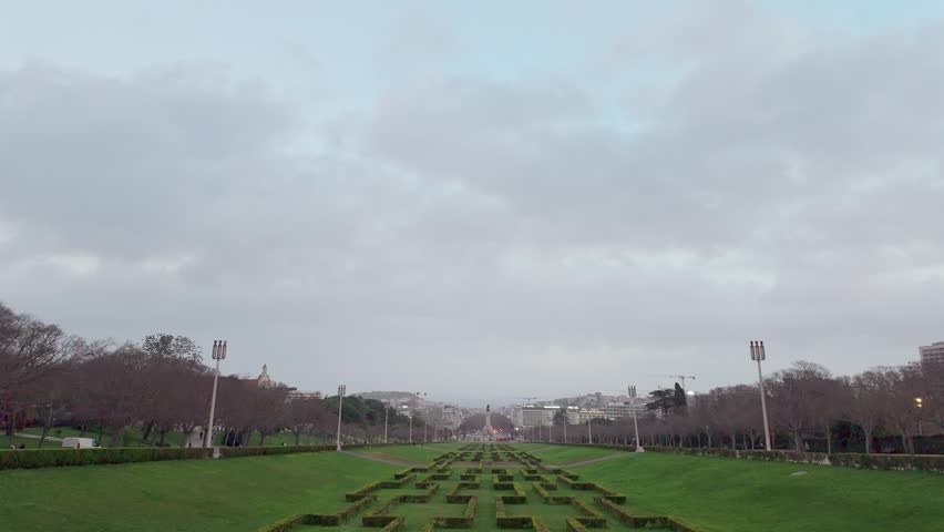 Photographer's perspective capturing a scenic view of Parque Eduardo VII in Lisbon, with the camera's viewfinder and settings visible, culminating in the final bright captured image