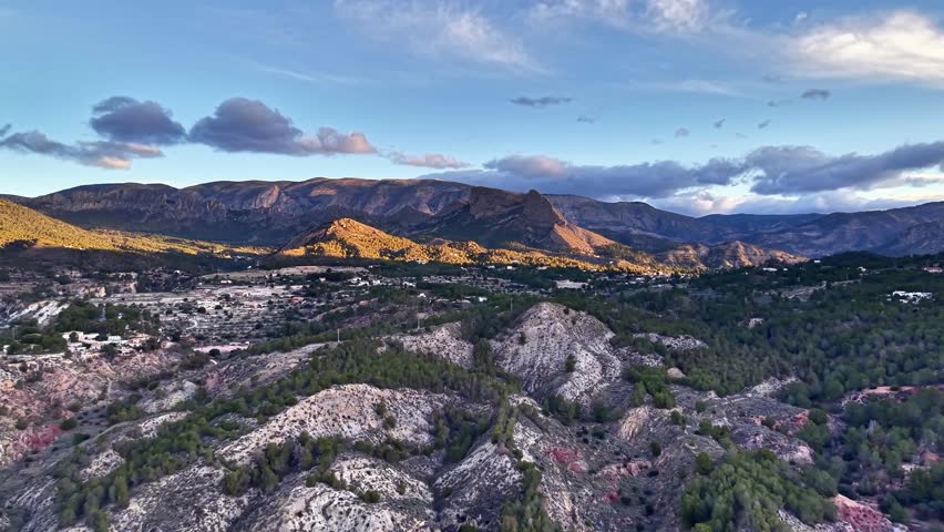 Sunset Mountain Valley Aerial Panoramic View Showing Golden Light Casting Long Shadows Across Rocky Outcrops,