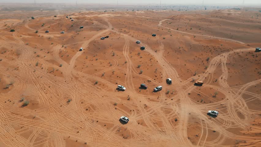 Off-road vehicles navigate sand dunes during a desert safari in the UAE.