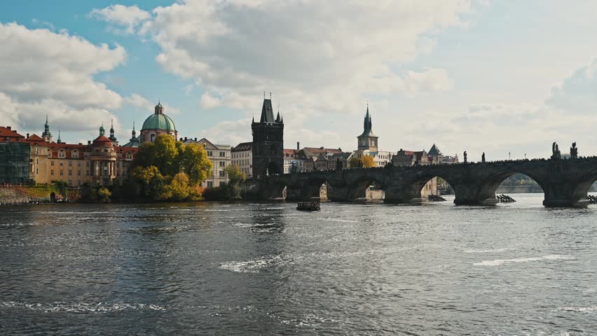 Amazing panoramic view of Charles Bridge on Vltava River in Prague. Historical buildings line on riverbanks.