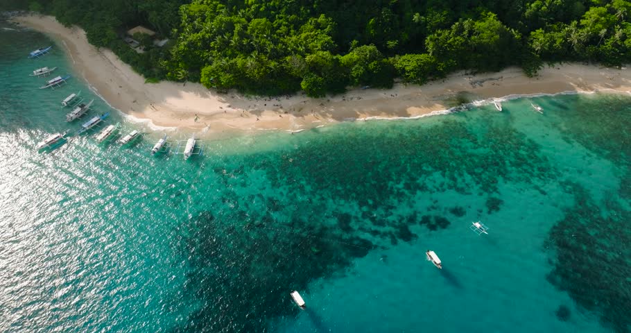 Top view of tourboat on Helicopter Beach. Turquoise sea water and corals. El Nido, Palawan. Philippines.